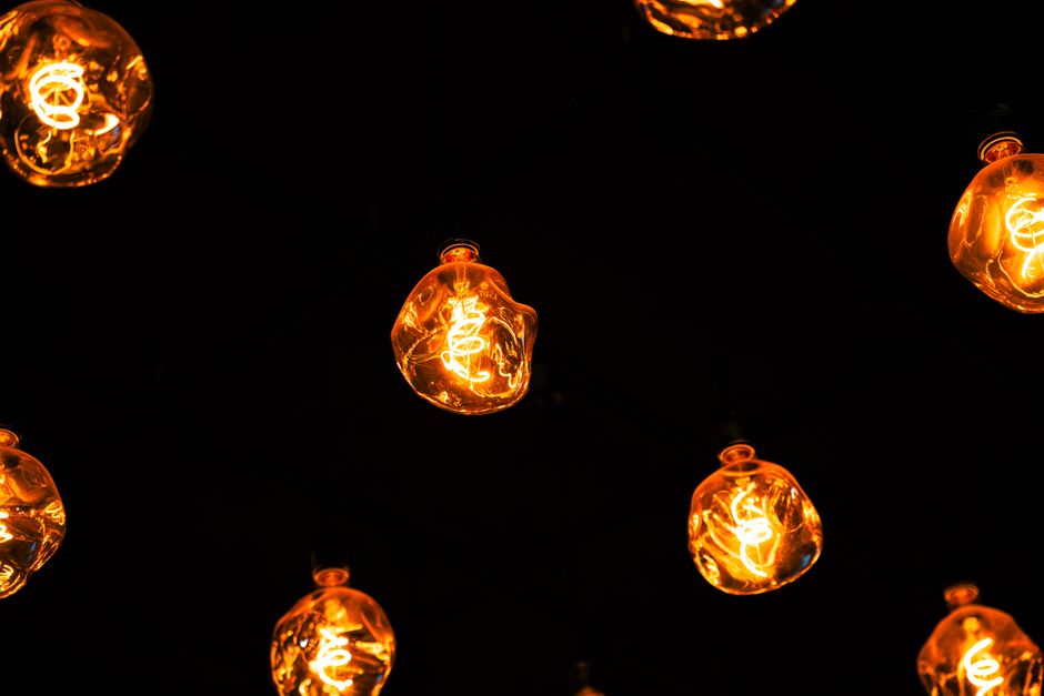 Sfeervolle verlichting in een modern interieur met verschillende lampen zoals hanglampen en vloerlampen.